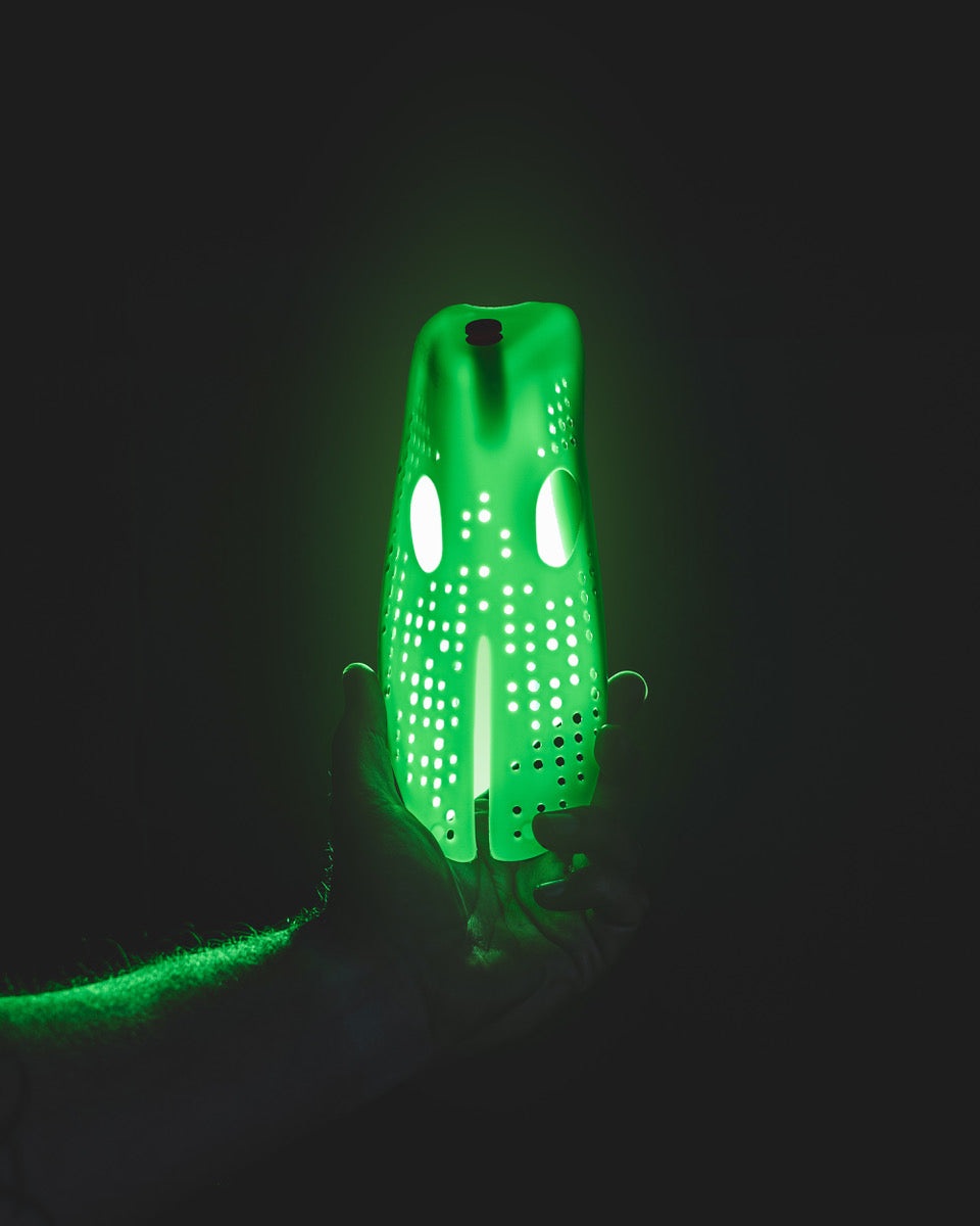 Odor Removing Shoe Insert displayed in a hand, glowing green, designed to eliminate unpleasant shoe odors.