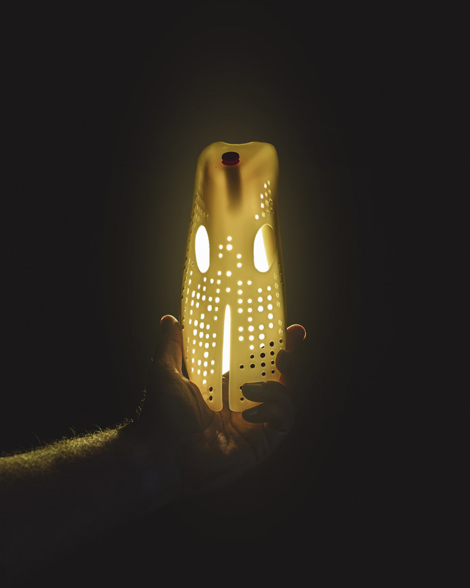 Hand holding a glowing odor remover shoe insert to eliminate smelly shoes.