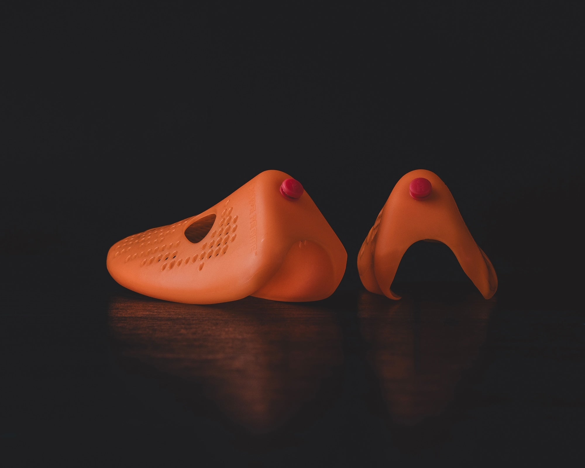 Stinky Sneakers shoe inserts in orange color designed to eliminate odors in footwear.